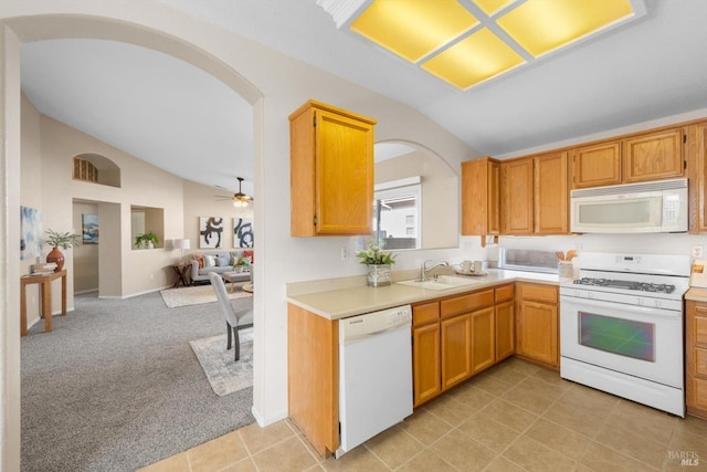 kitchen with open floor plan, light colored carpet, light countertops, vaulted ceiling, and white appliances