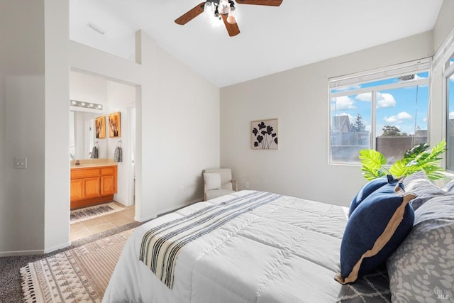 bedroom featuring connected bathroom, ceiling fan, baseboards, vaulted ceiling, and light carpet