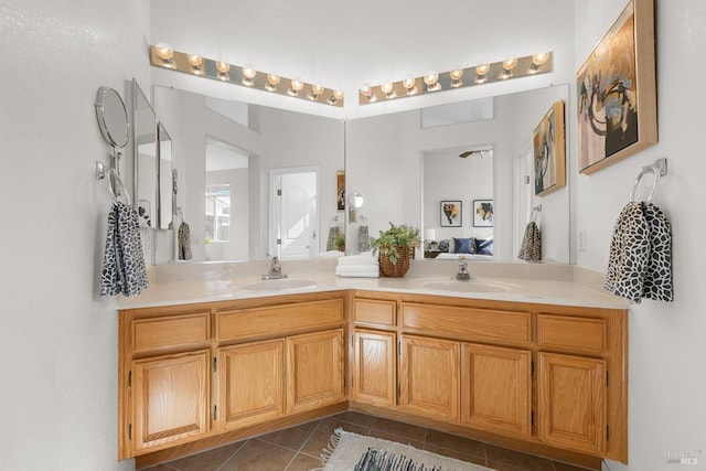 ensuite bathroom with tile patterned floors, connected bathroom, double vanity, and a sink