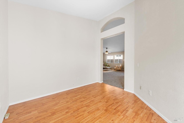 spare room featuring baseboards and light wood finished floors