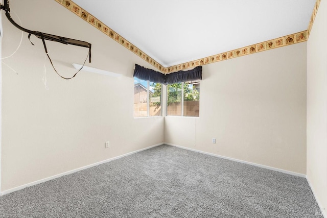 carpeted spare room featuring baseboards