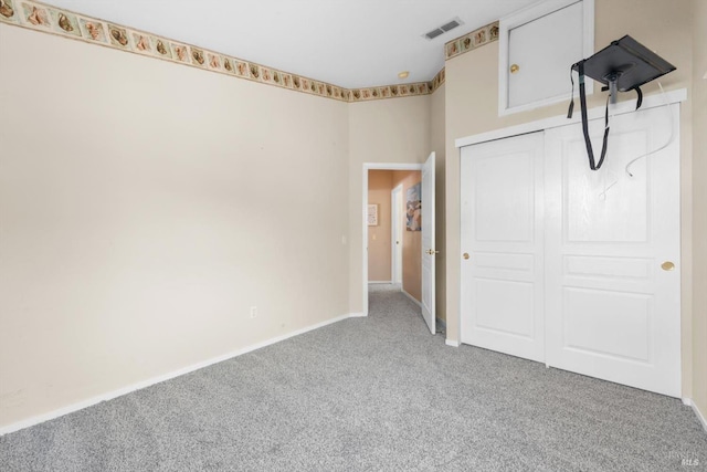 unfurnished bedroom featuring visible vents, baseboards, a closet, and carpet flooring