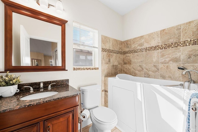 bathroom with a bath, toilet, and vanity