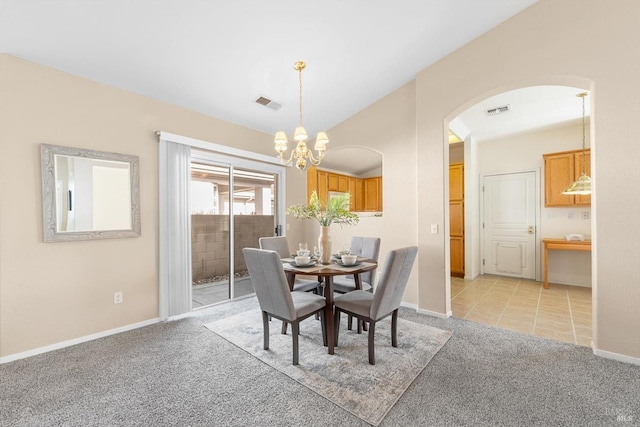 dining area featuring visible vents, an inviting chandelier, lofted ceiling, arched walkways, and light carpet