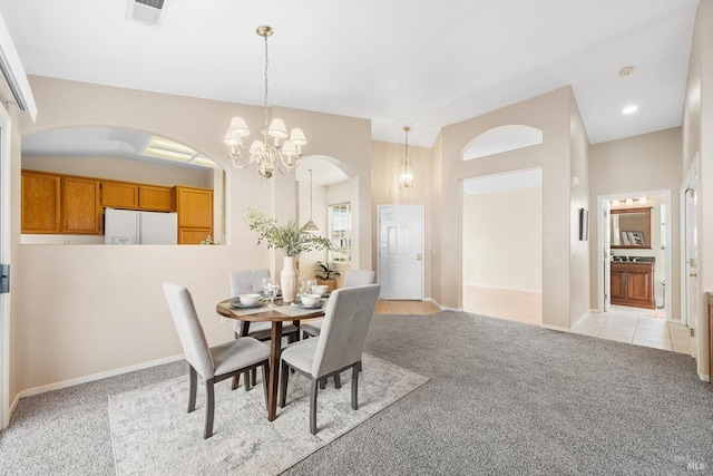 dining room featuring visible vents, arched walkways, light colored carpet, and a chandelier