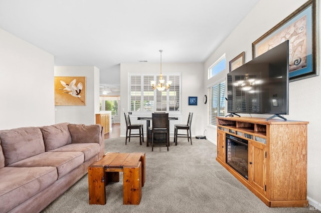 living area featuring an inviting chandelier, baseboards, and light colored carpet