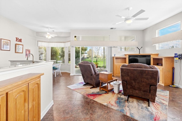 tiled living room featuring ceiling fan, baseboards, visible vents, and a healthy amount of sunlight