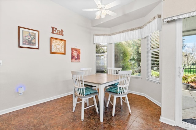 dining area with ceiling fan and baseboards