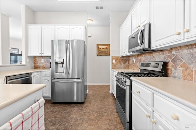 kitchen featuring appliances with stainless steel finishes, white cabinets, visible vents, and tasteful backsplash