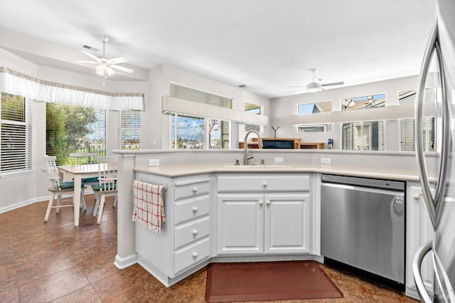 kitchen with light countertops, appliances with stainless steel finishes, a sink, and a ceiling fan