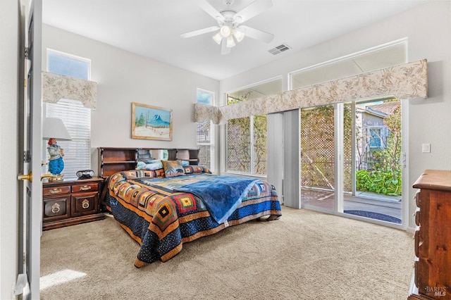 carpeted bedroom featuring ceiling fan, access to outside, and visible vents