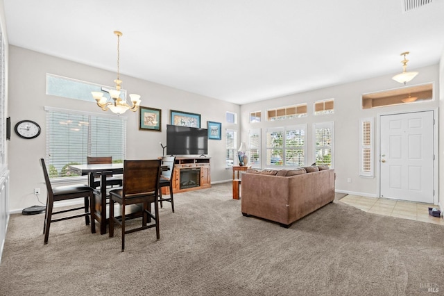 living area featuring a chandelier, carpet, visible vents, and baseboards