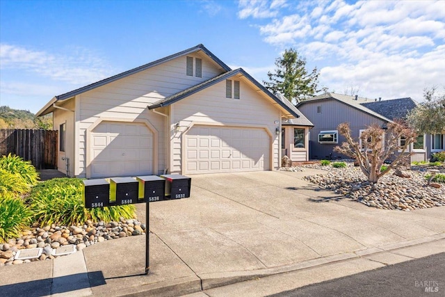 view of front facade featuring a garage, fence, and concrete driveway