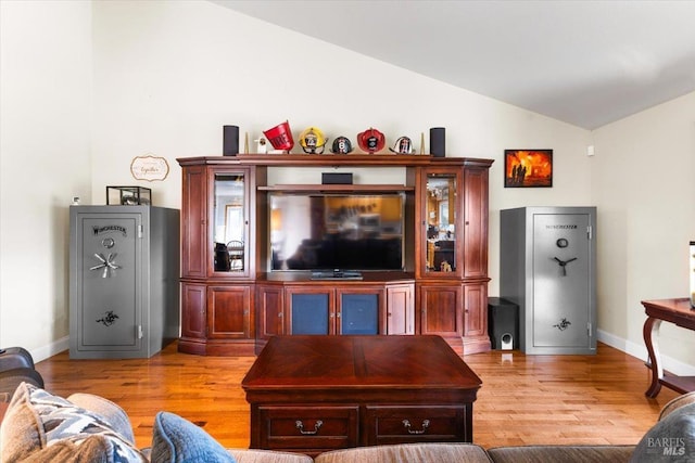 living room featuring baseboards, lofted ceiling, and light wood-style flooring