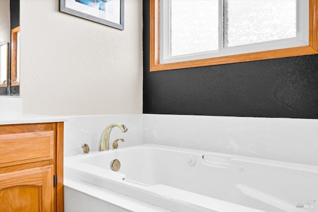 full bathroom featuring a wealth of natural light, vanity, and a garden tub