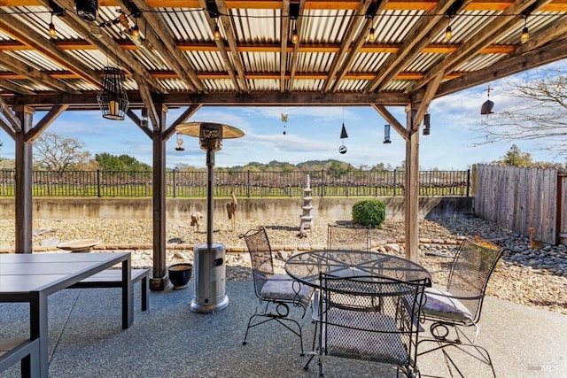 view of patio / terrace with outdoor dining space, a fenced backyard, and a water view