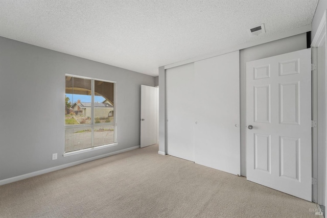 unfurnished bedroom featuring carpet, a closet, and a textured ceiling