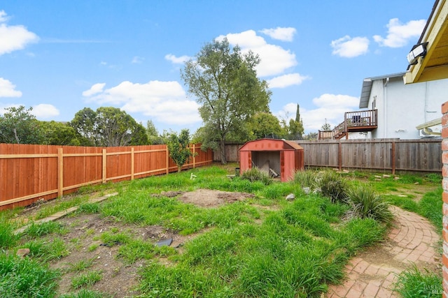 view of yard featuring an outbuilding, a fenced backyard, and a shed