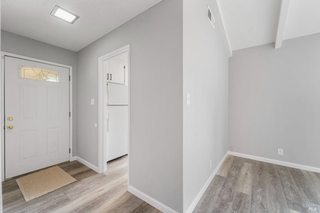 entrance foyer with visible vents, baseboards, and wood finished floors