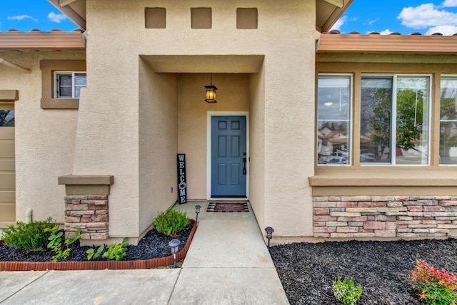 view of exterior entry featuring stucco siding