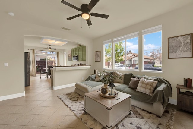 living area featuring a wealth of natural light, arched walkways, and light tile patterned floors