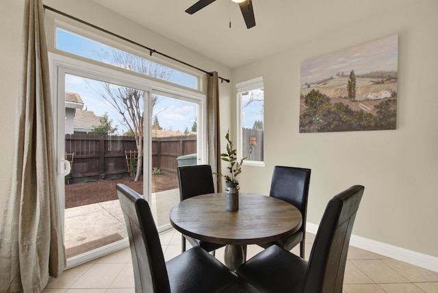 dining area featuring ceiling fan, light tile patterned flooring, and baseboards