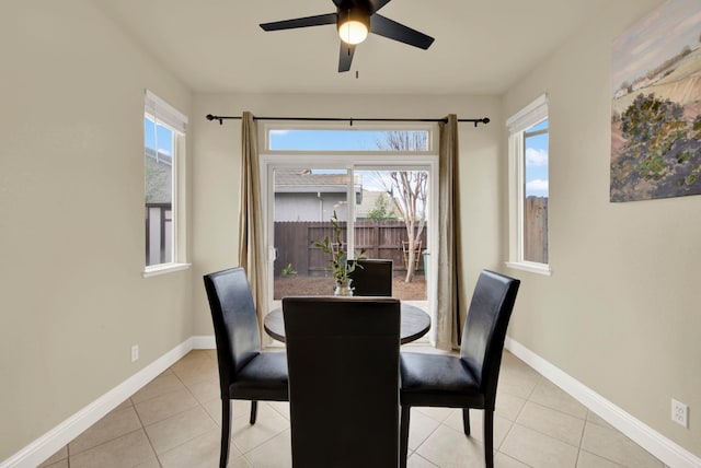 dining space featuring light tile patterned floors, ceiling fan, and baseboards