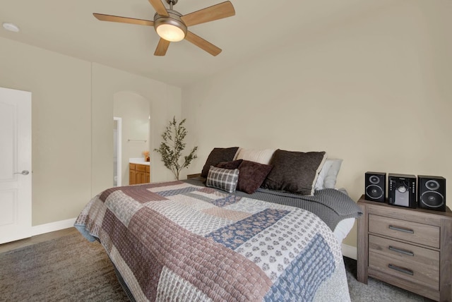 bedroom featuring arched walkways, ceiling fan, carpet flooring, and baseboards