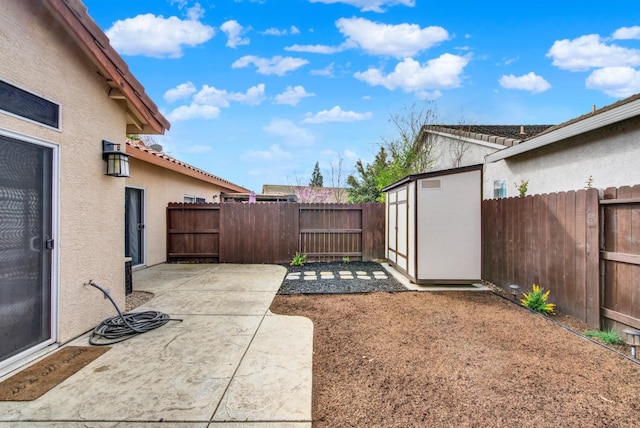 view of yard with an outbuilding, a patio, a storage shed, and a fenced backyard