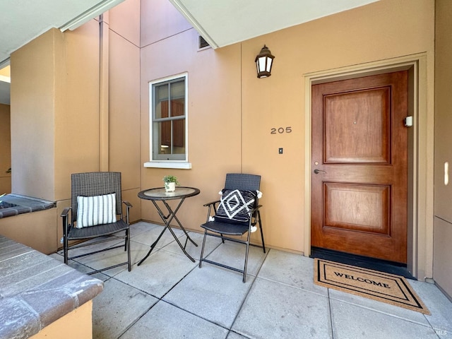 entrance to property with a patio and stucco siding