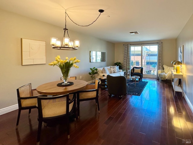 dining space with visible vents, dark wood finished floors, a notable chandelier, and baseboards