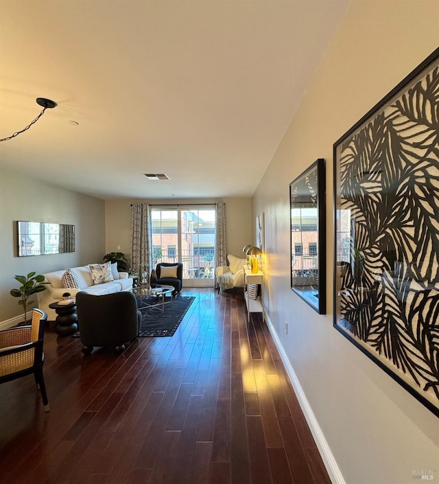 living room featuring baseboards, visible vents, and dark wood finished floors