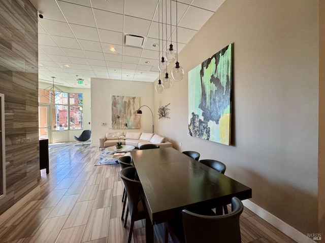 dining room with a paneled ceiling, baseboards, and visible vents