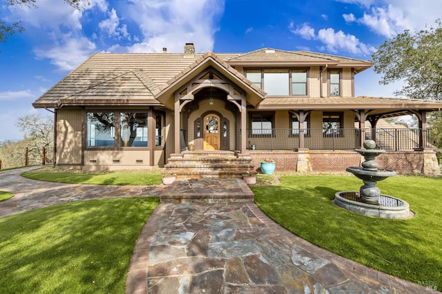 view of front of property with a tiled roof, crawl space, a chimney, and a front yard