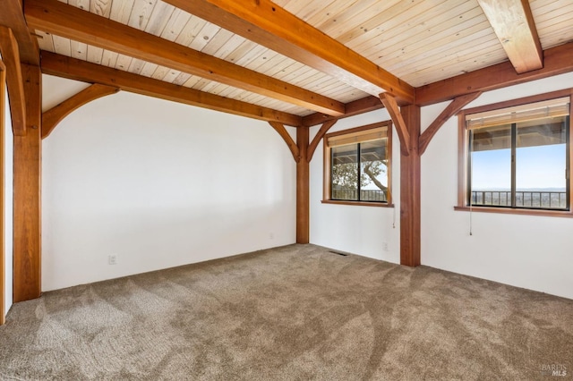 carpeted empty room with visible vents, wooden ceiling, and beam ceiling