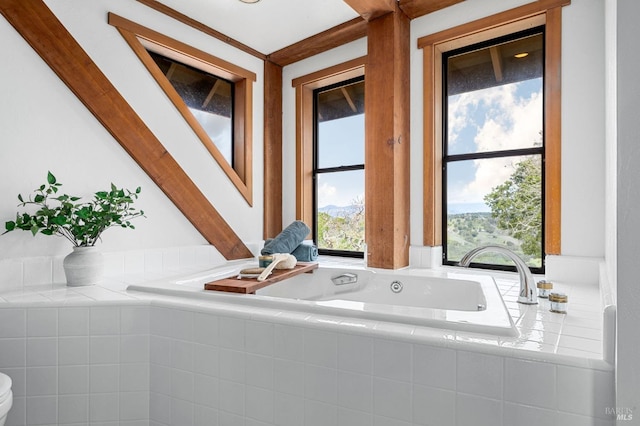 full bath featuring a jetted tub, toilet, and a wealth of natural light