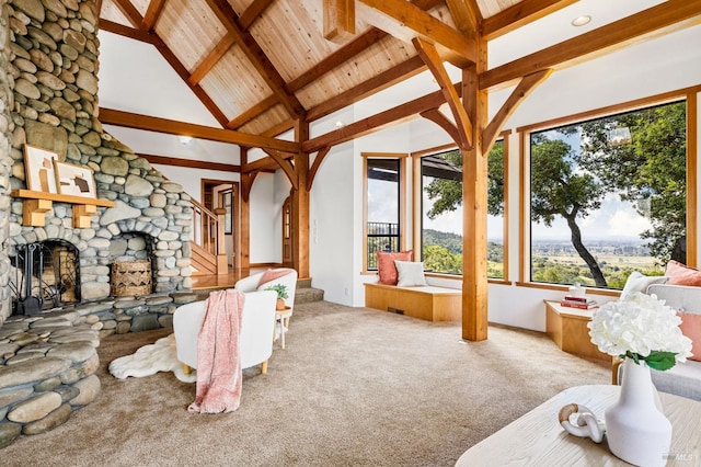 sunroom featuring lofted ceiling with beams, a fireplace, and wood ceiling