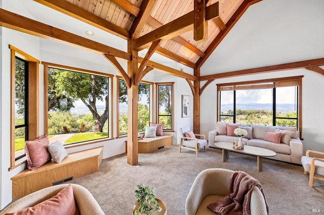 sunroom with a healthy amount of sunlight, lofted ceiling with beams, and visible vents