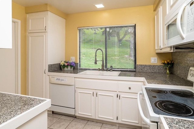 kitchen with white appliances, tile countertops, light tile patterned flooring, a sink, and white cabinets