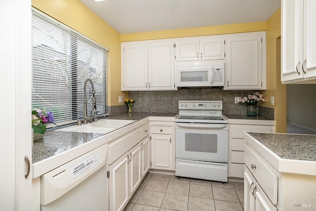 kitchen featuring a sink, tile countertops, white appliances, light tile patterned floors, and a healthy amount of sunlight