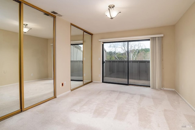 empty room featuring carpet flooring, baseboards, and visible vents