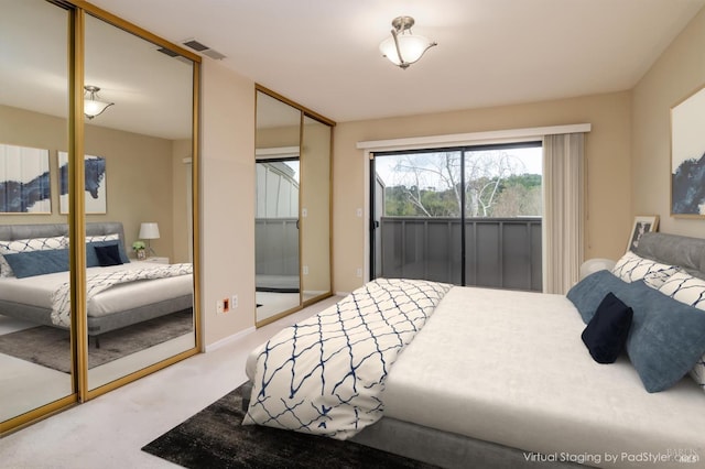 carpeted bedroom featuring visible vents, baseboards, and two closets