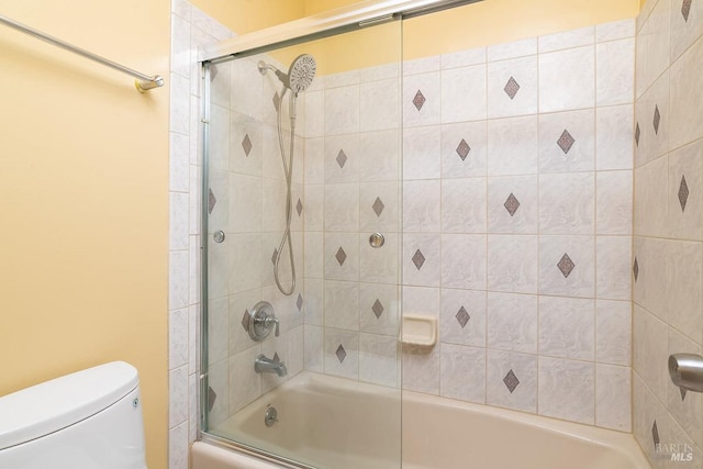 full bathroom with enclosed tub / shower combo and toilet