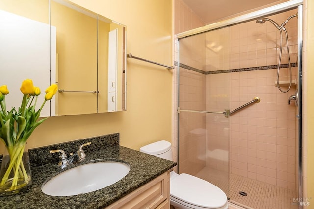 full bath featuring toilet, a stall shower, and vanity