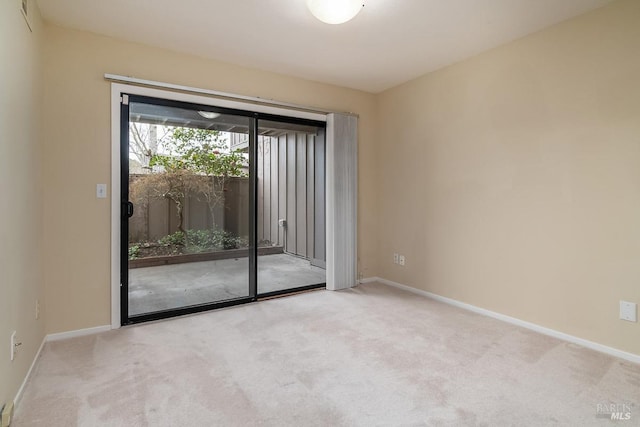 carpeted empty room featuring baseboards