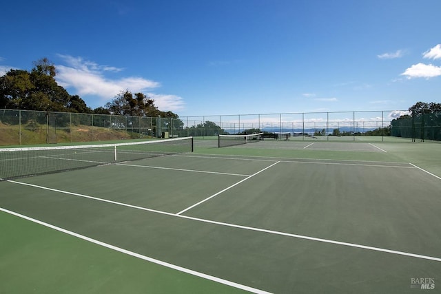 view of tennis court featuring fence