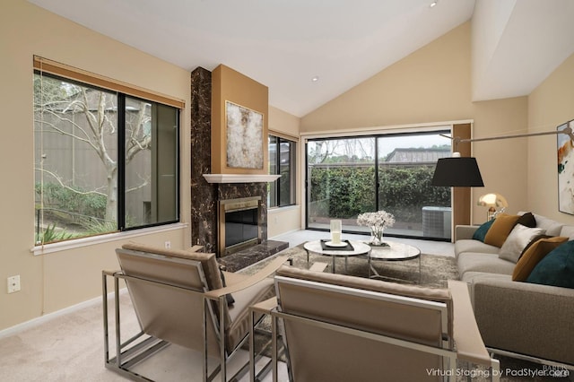 living room with vaulted ceiling, baseboards, a glass covered fireplace, and carpet floors