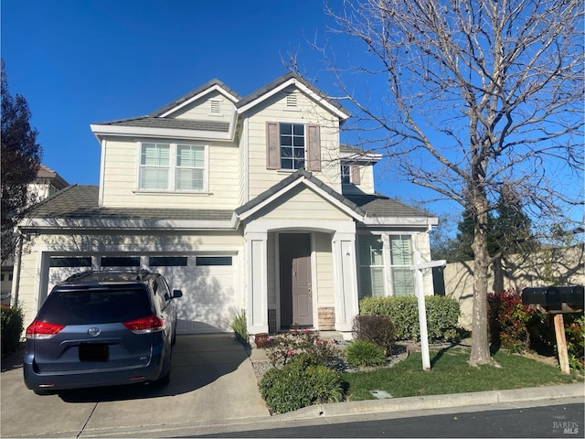 traditional-style home featuring a garage and driveway