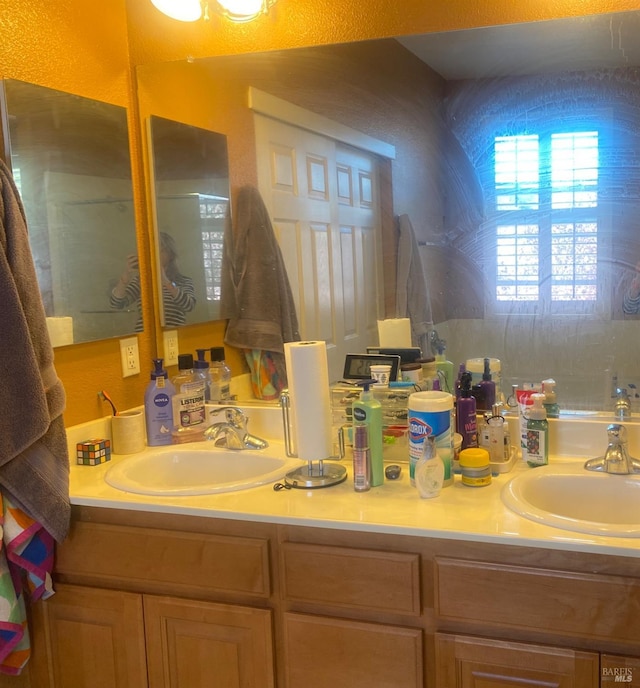 full bathroom with double vanity and a sink