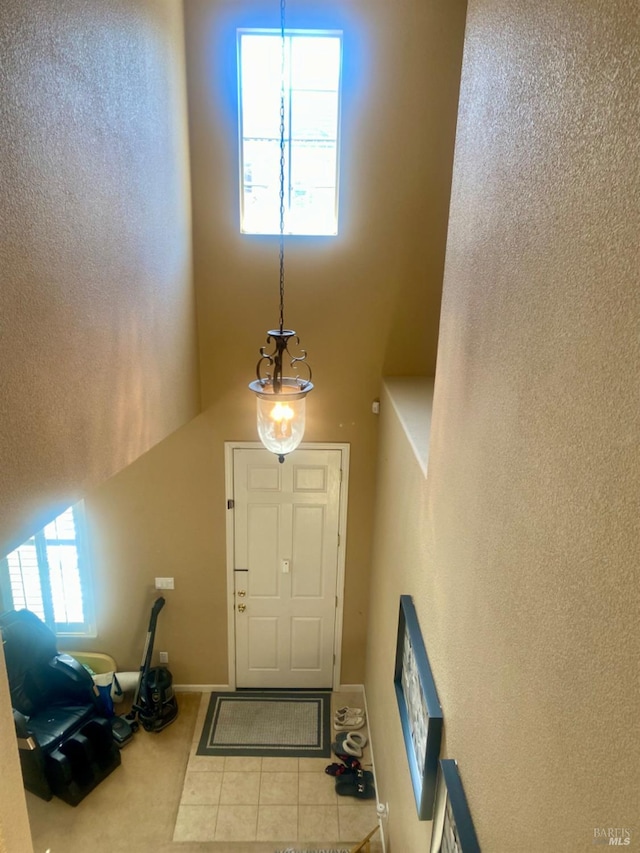 tiled foyer with a healthy amount of sunlight and baseboards